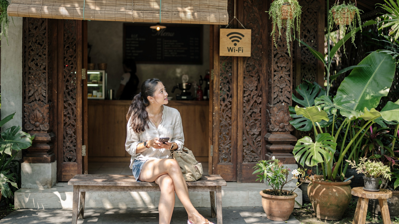 A digital nomad in Bali attempts to connect to a local Wi-Fi, showing a mix of traditional Balinese architecture and modern tech.