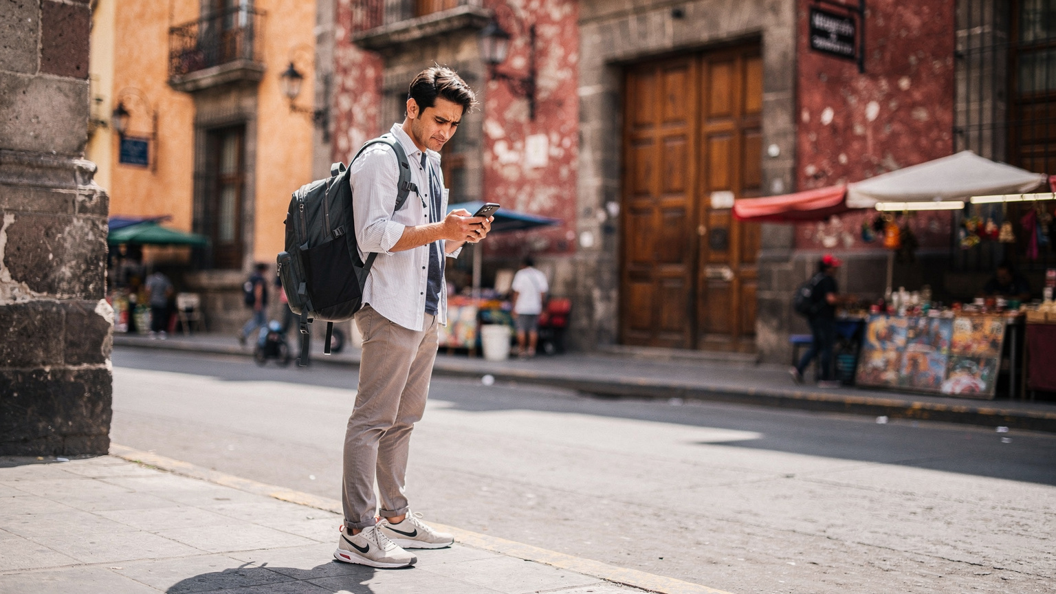 A person navigating the bustling streets of Mexico City, looking at their phone, trying to find directions, with a slightly concerned expression, highlighting a moment of potential connectivity challenge.